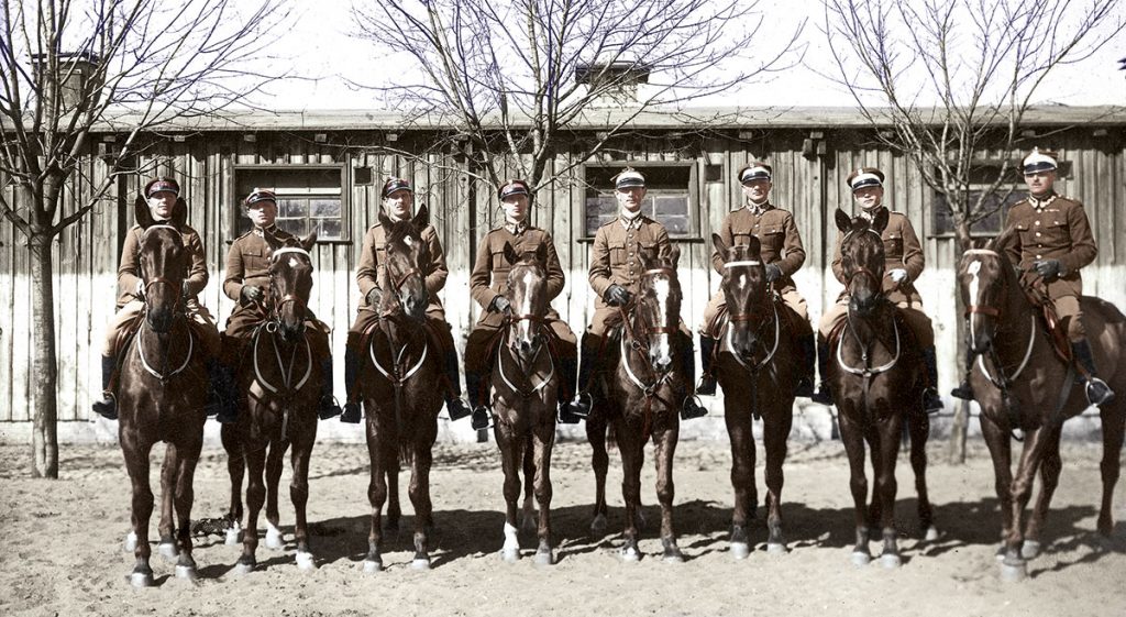 Polska ekipa w Centrum Wyszkolenia Kawalerii w Grudziądzu przed wyjazdem do Nicei i Rzymu. Pierwszy od lewej Adam Królikiewicz, czwarty od lewej Zdzisław Dziadulski, szósty od lewej Henryk Dobrzański – słynny „Hubal”. Źródło: Narodowe Archiwum Cyfrowe