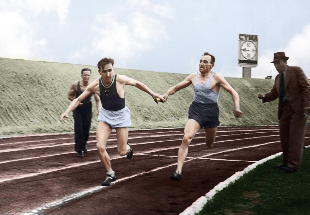 Józef Noji (z prawej) przekazuje pałeczkę Januszowi Kusocińskiemu podczas sztafety 4×1500 m (wielka rewia asów zorganizowana przez Związek Dziennikarzy Sportowych w czerwcu 1939). Stadion Wojska Polskiego im. Marszałka Józefa Piłsudskiego (Stadion Legii Warszawa) Fot. NAC