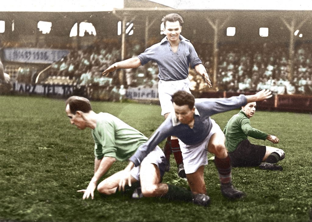 Mecz piłki nożnej Wisła Kraków – Warta Poznań w Krakowie we wrześniu 1938 r. Antoni Łyko z Wisły strzela drugą bramkę po wyminięciu bramkarza Warty Zbigniewa Schultza. Obok niego Konrad Ofierzyński z Warty Poznań, nad nim Michał Filek z Wisły Kraków. W tle widoczne trybuny i loża honorowa Fot. NAC