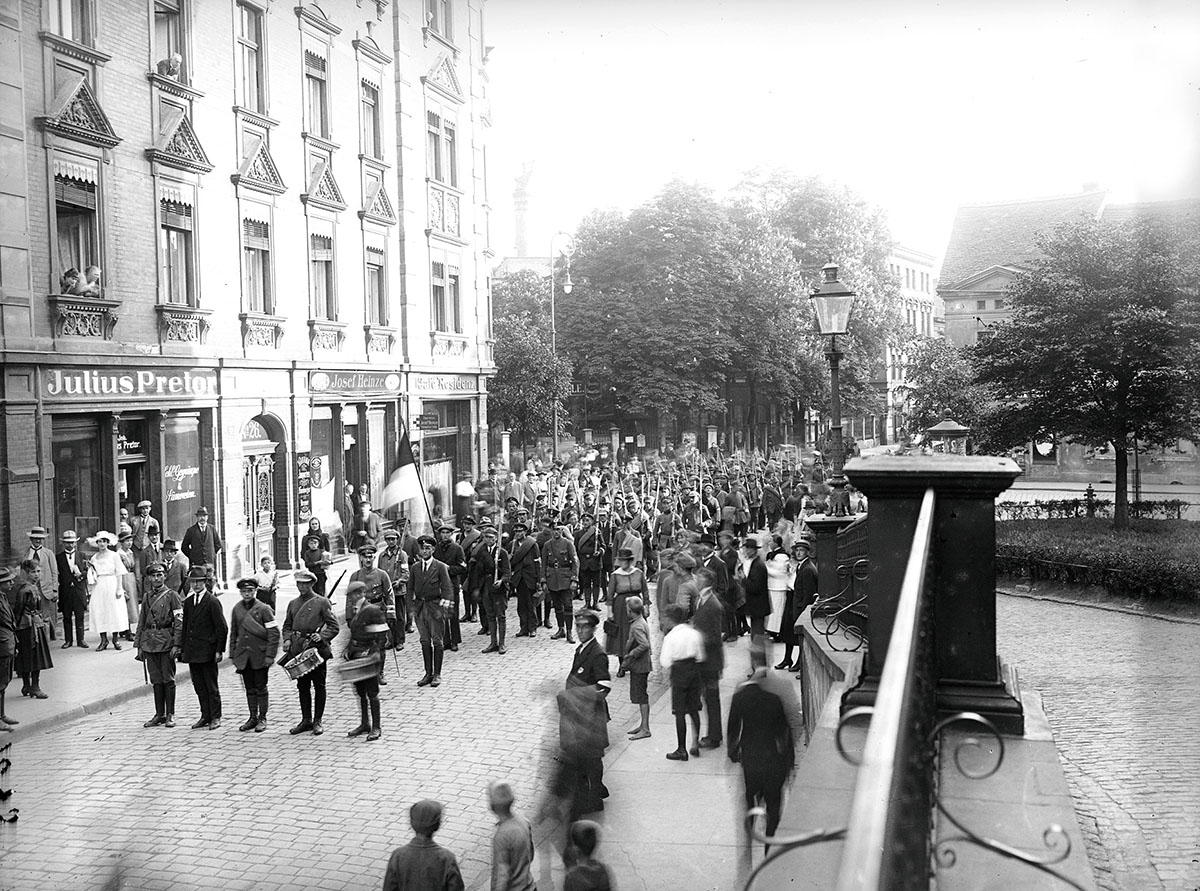 Racibórz w czasie III Powstania Śląskiego. Przemarsz oddziałów samoobrony (Selbstschutz) przez Troppauerstrasse (ul. Opawska) – widok spod gmachu sądu przy Neuestrasse (ul. Nowa). Źródło: Narodowe Archiwum Cyfrowe